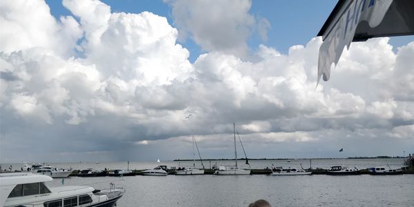 Sailboats moored in sea against sky