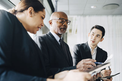 Senior businessman discussing ideas with colleagues in conference room at office