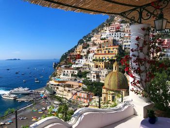 Panoramic view of positano town by sea against clear sky
