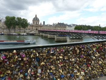 Padlocks on bridge over river in city