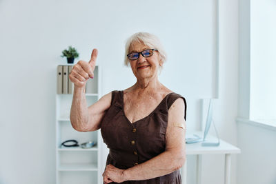 Portrait of senior woman gesturing at hospital
