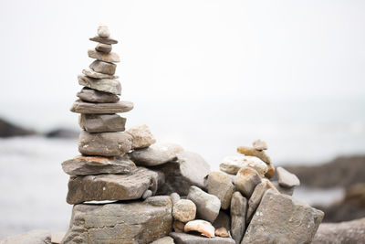 Stack of pebbles on beach against sky