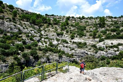 Man walking on mountain against sky