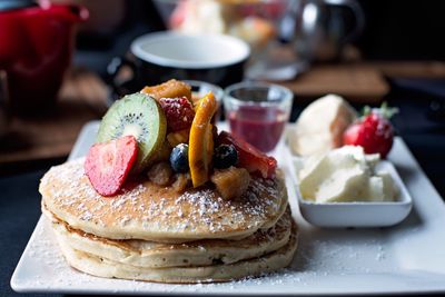 High angle view of fruits and pancakes served on table