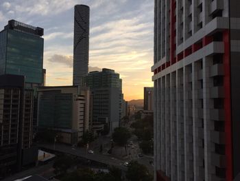 Skyscrapers in city at sunset