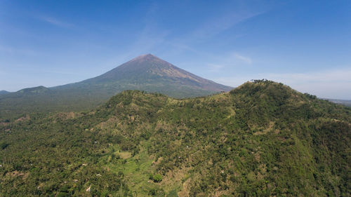 Aerial view of volcano mount agung with smoke billowing out at sunrise, bali, indonesia. 