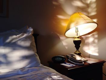 Close-up of electric lamp on bed