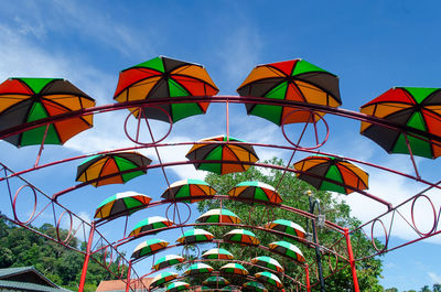 Low angle view of multi colored umbrellas against sky