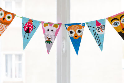 Close-up of multi colored umbrellas hanging against white background