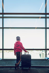 Rear view of man on airport against clear sky