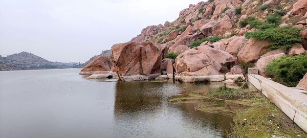 Rock formations by sea against sky