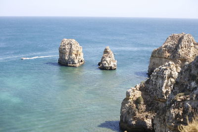 Rock formations in sea against clear sky