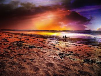 Scenic view of beach against cloudy sky