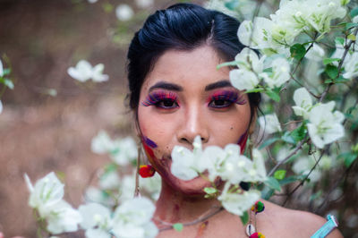 Close-up portrait of young woman with flowers