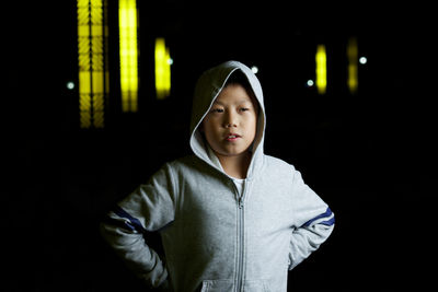 Boy with hands on hip standing in darkroom