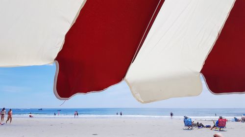 People at beach against sky