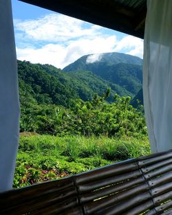 Scenic view of mountains against sky seen through window