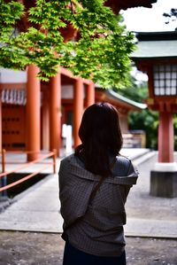 Rear view of woman standing against shrine 