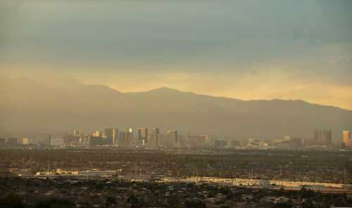 High angle view of buildings and mountains against sky at sunset