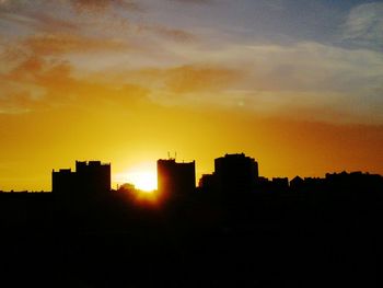 Silhouette buildings against sky during sunset