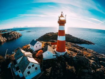 Lighthouse by sea against sky in city