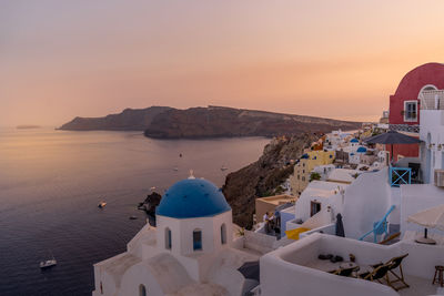 High angle view of sea and buildings against sky during sunset