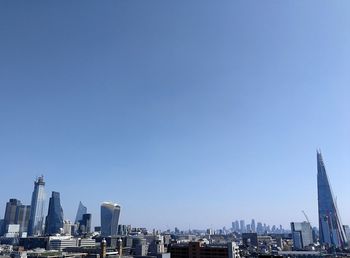 Buildings in city against blue sky