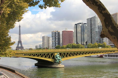 Low angle view of bridge over river against cloudy sky