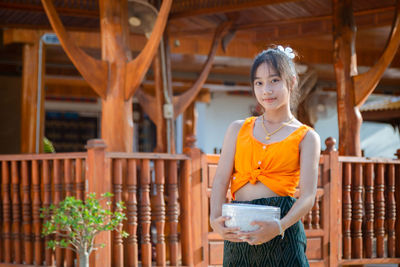 Young woman standing against railing