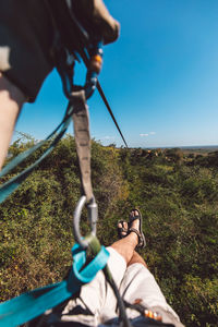 Midsection of man holding rope against sky