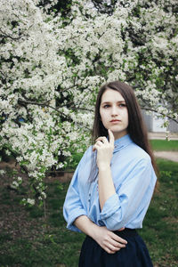 Portrait of beautiful young woman standing by plants