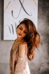 Portrait of beautiful woman standing against wall