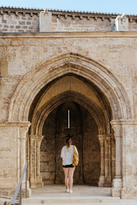 Girl looking at a church's arch with a backpack