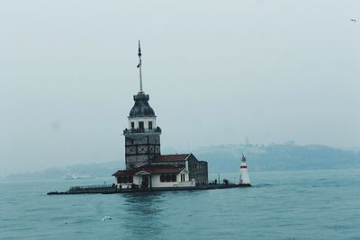Lighthouse sailing on sea against sky