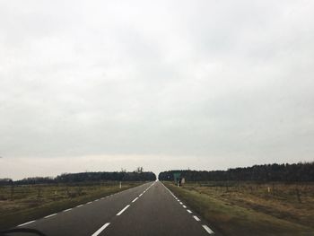 Road amidst field against sky