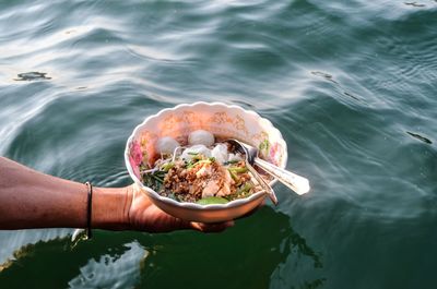 High angle view of person holding food in sea