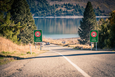 Information sign by road against trees