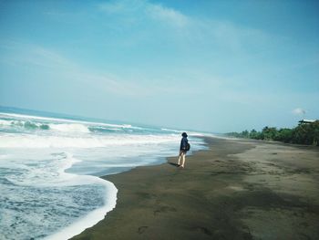 Full length of woman on beach against clear sky