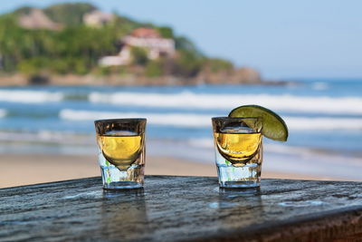 Close-up of drink on table at beach