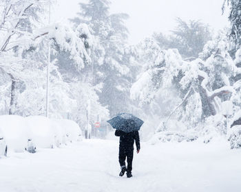 Young couple walking on a city street during heavy snow storm. storm filomena in madrid