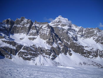 Scenic view of snowcapped mountains against clear blue sky