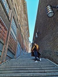 Low angle view of woman walking on building in city