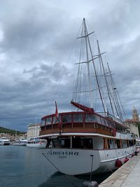 Sailboats moored at harbor against sky