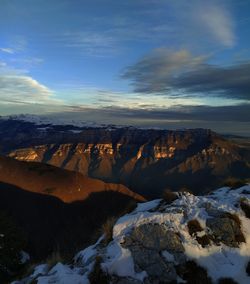 Aerial view of snowcapped mountains against sky during sunset