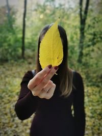 Portrait of woman holding leaves outdoors