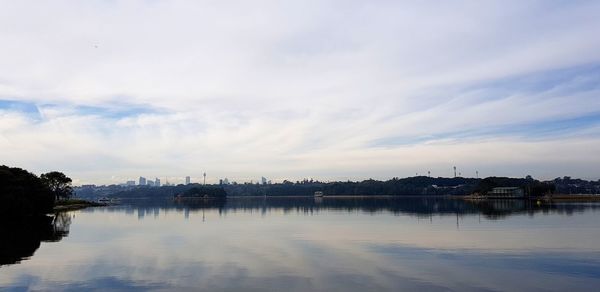 Scenic view of lake by buildings against sky