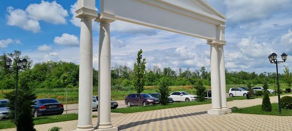 Cars on street against sky in city
