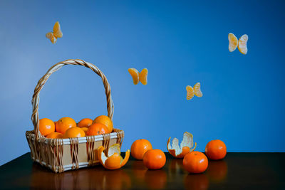 Orange fruits on table against blue sky