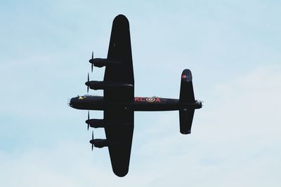 Low angle view of airplane flying against sky