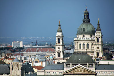 Buildings in city against clear sky